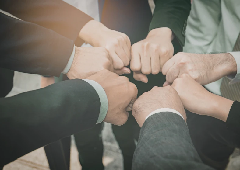Hands in a circle showing teamwork and collaboration